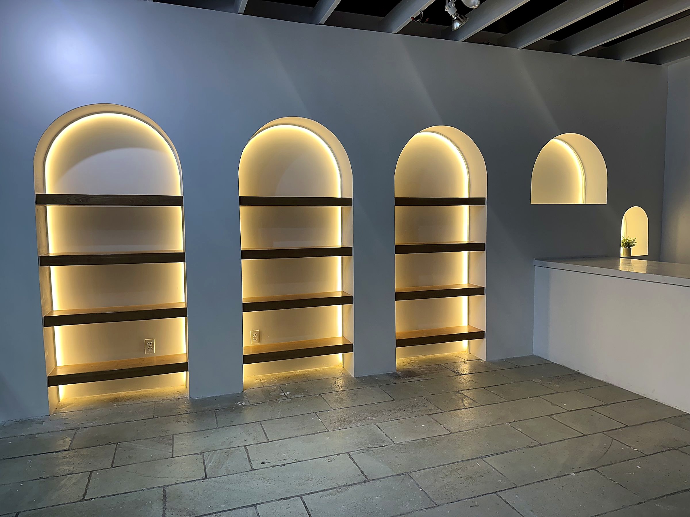 Interpretation Centre Gift Shop at Dow's Hill — the completed wall of illuminated arched display niches, shelving installed, prior to merchandising