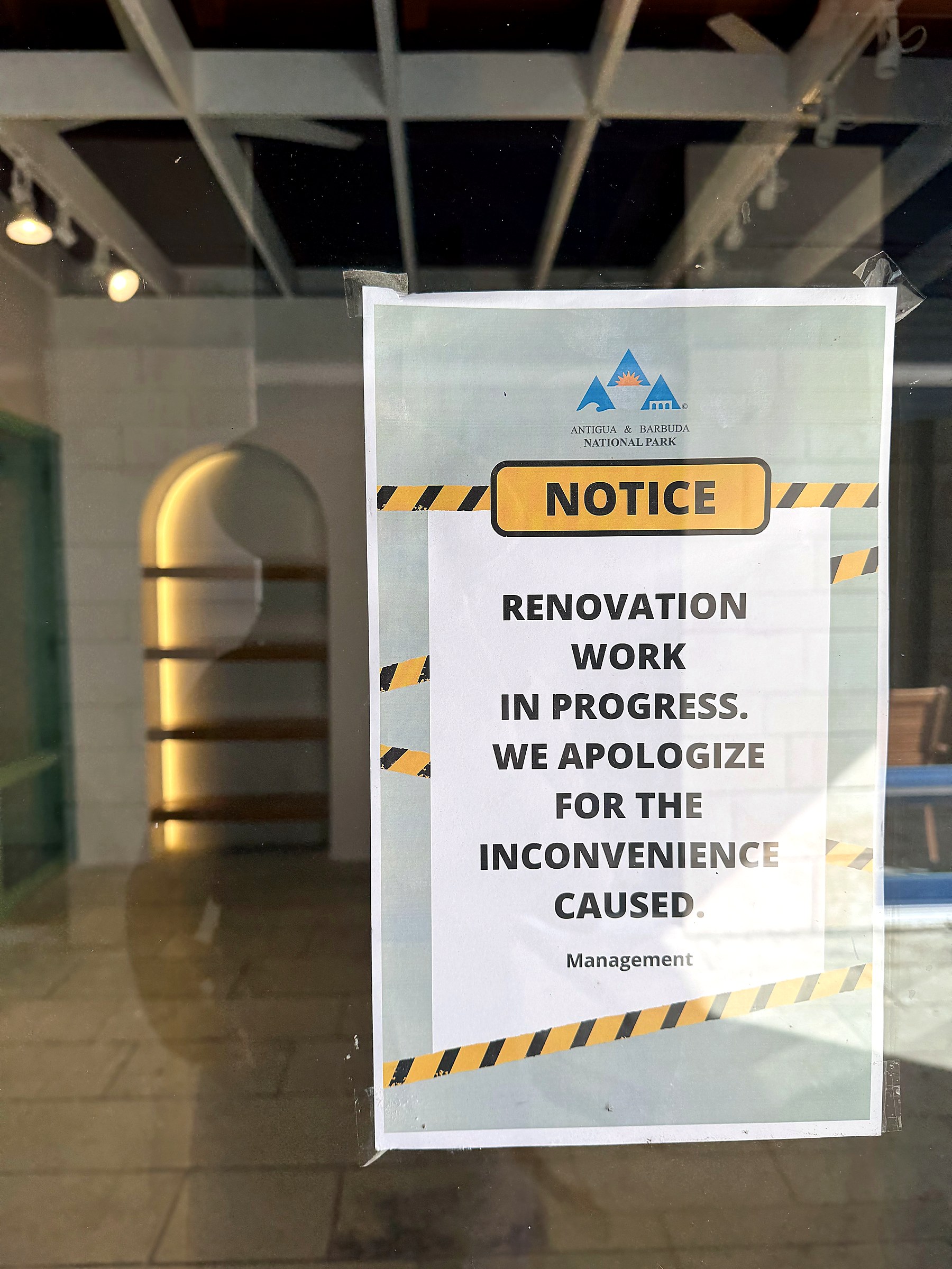 Interpretation Centre Gift Shop at Dow's Hill — storefront glass during renovation, showing a National Park notice sign and the arched display niches under construction beyond