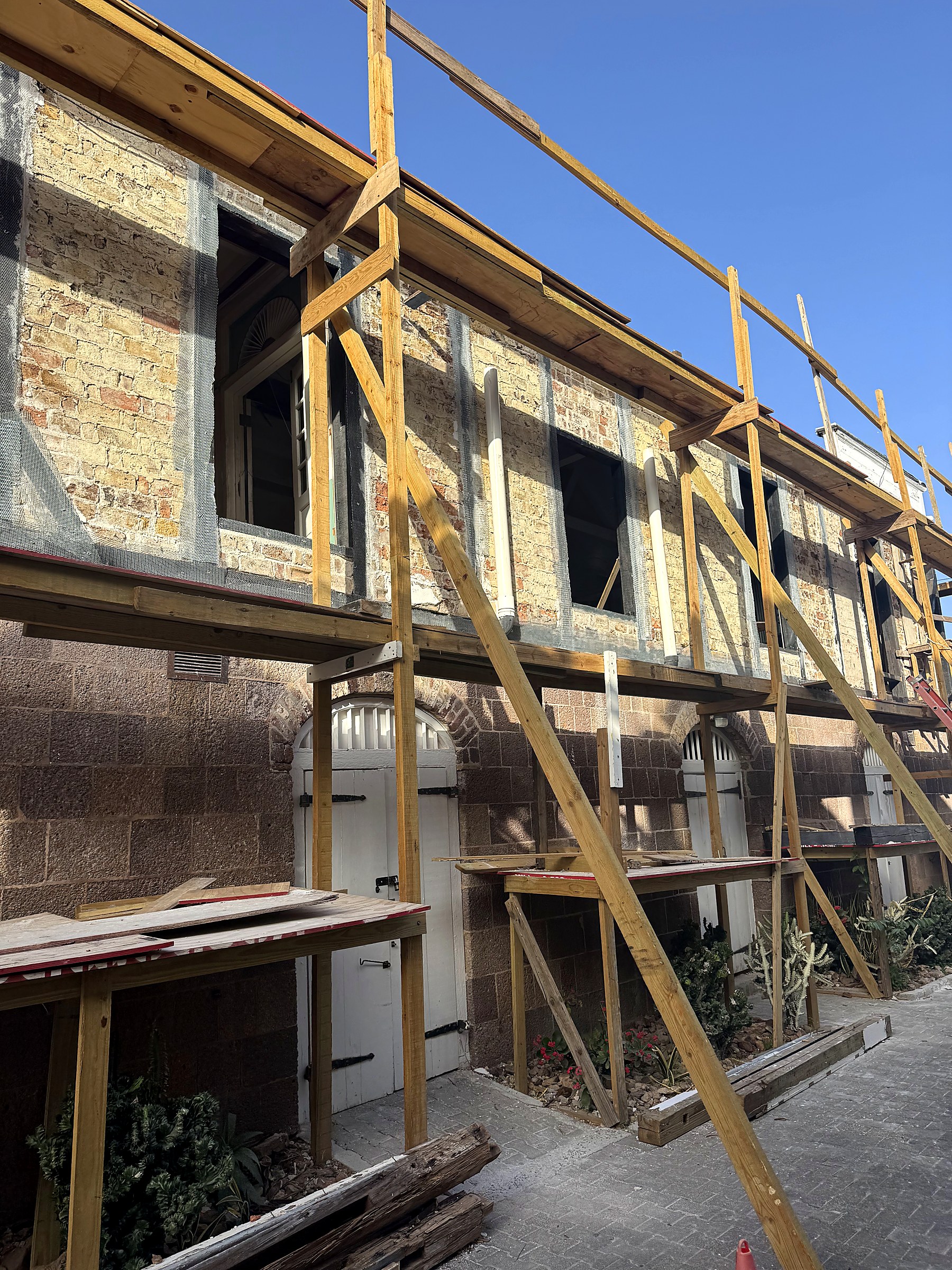 Officers' Quarters upper-story timber-frame infill during repair, new lath and mesh applied ahead of render